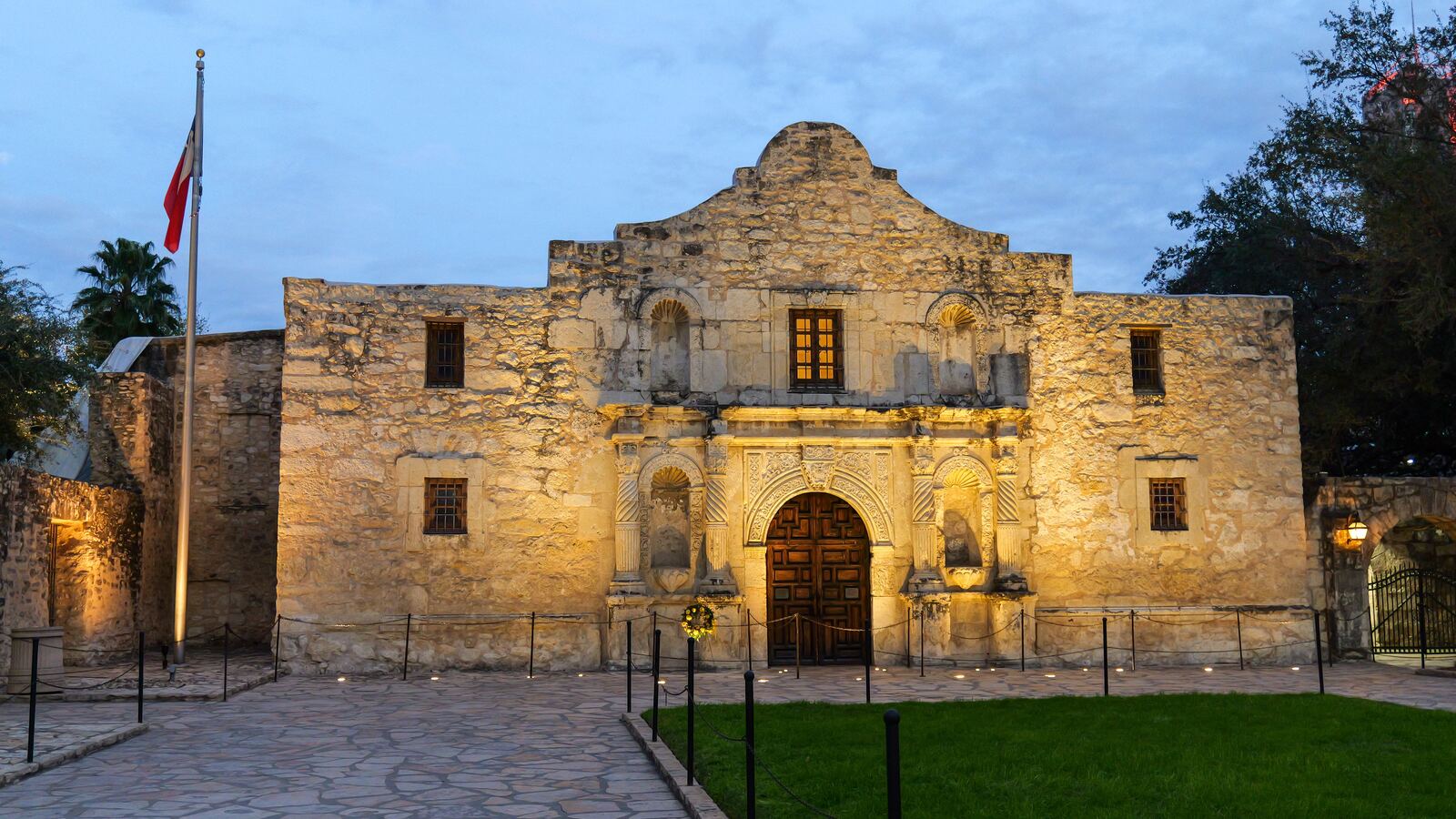 The Alamo floodlit against a dusk sky in San Antonio