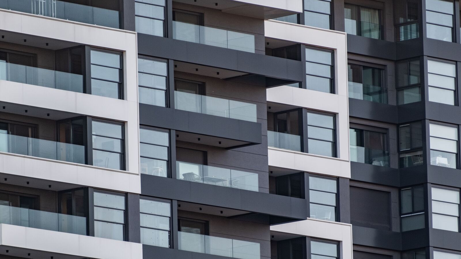 Modern apartment building facade with rows of recessed balconies