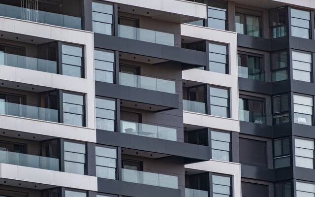 Modern apartment building facade with rows of recessed balconies