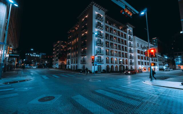 Balconied mid-rise building at a quiet downtown San Antonio crossing at night