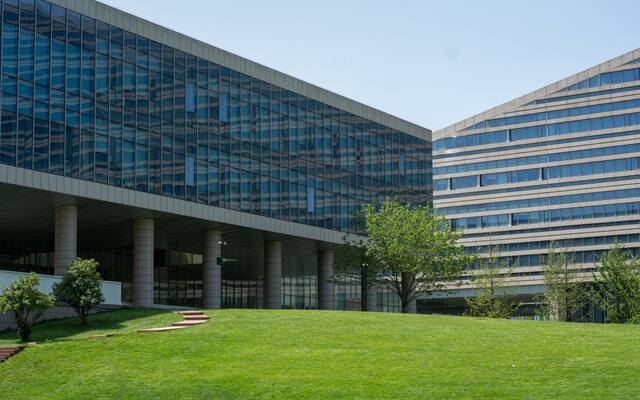 Modern glass office buildings set behind an open lawn