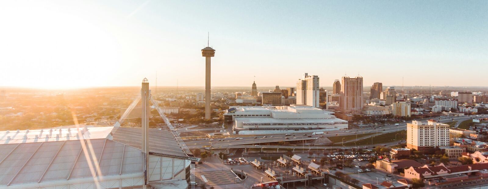 Aerial view of downtown San Antonio with the Tower of the Americas and the Alamodome at golden hour