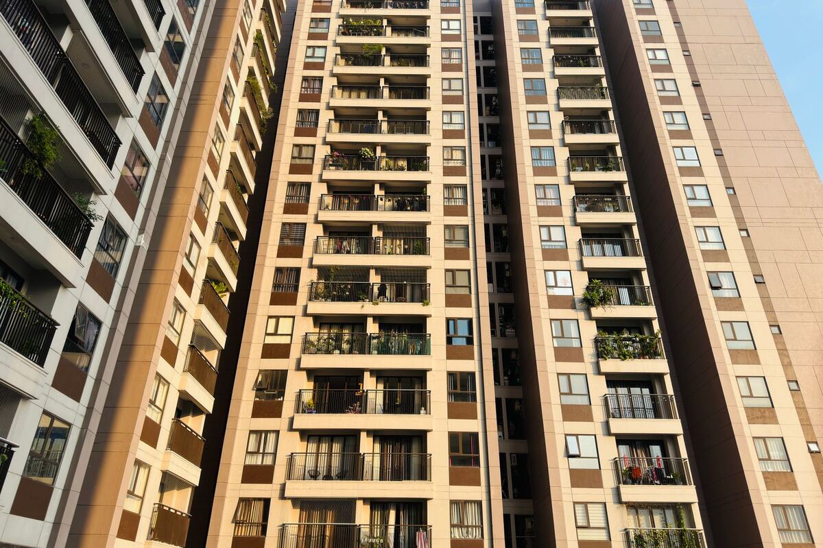 Two high-rise residential towers seen from below against a clear sky