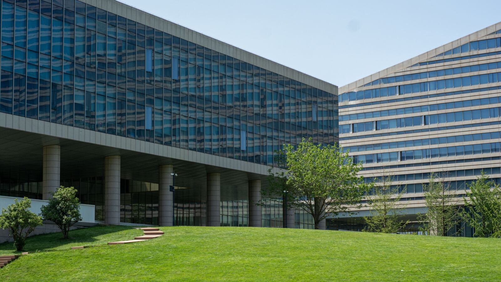 Modern glass office buildings set behind an open lawn