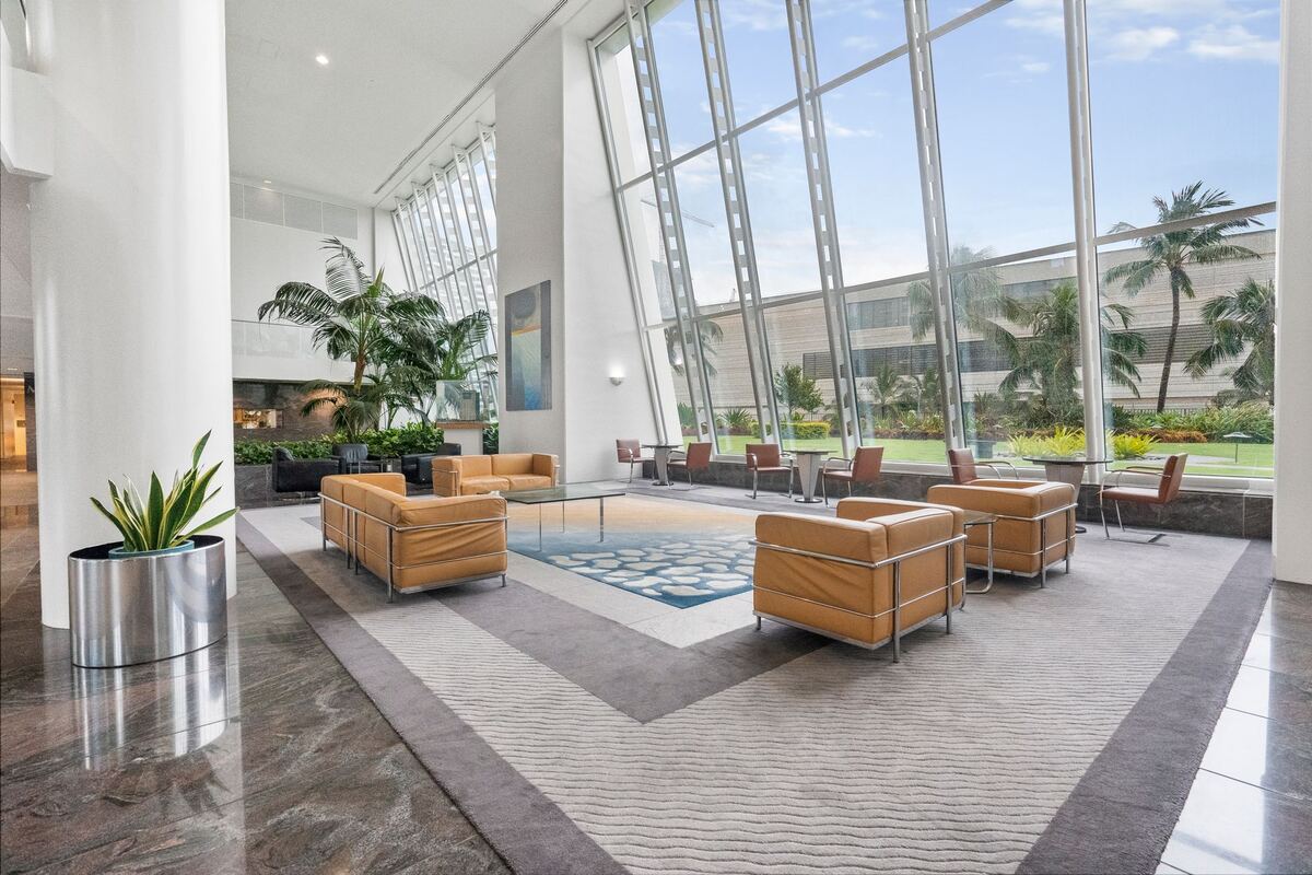 Office lobby seating beneath a full-height glass wall