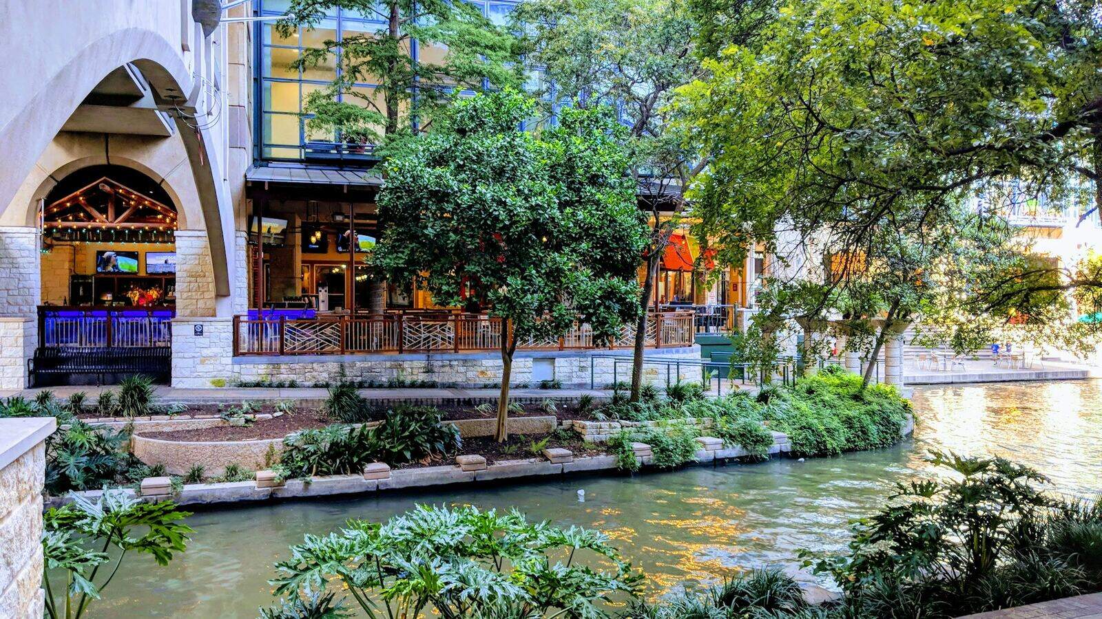 Daytime greenery and riverside terraces along the San Antonio River Walk