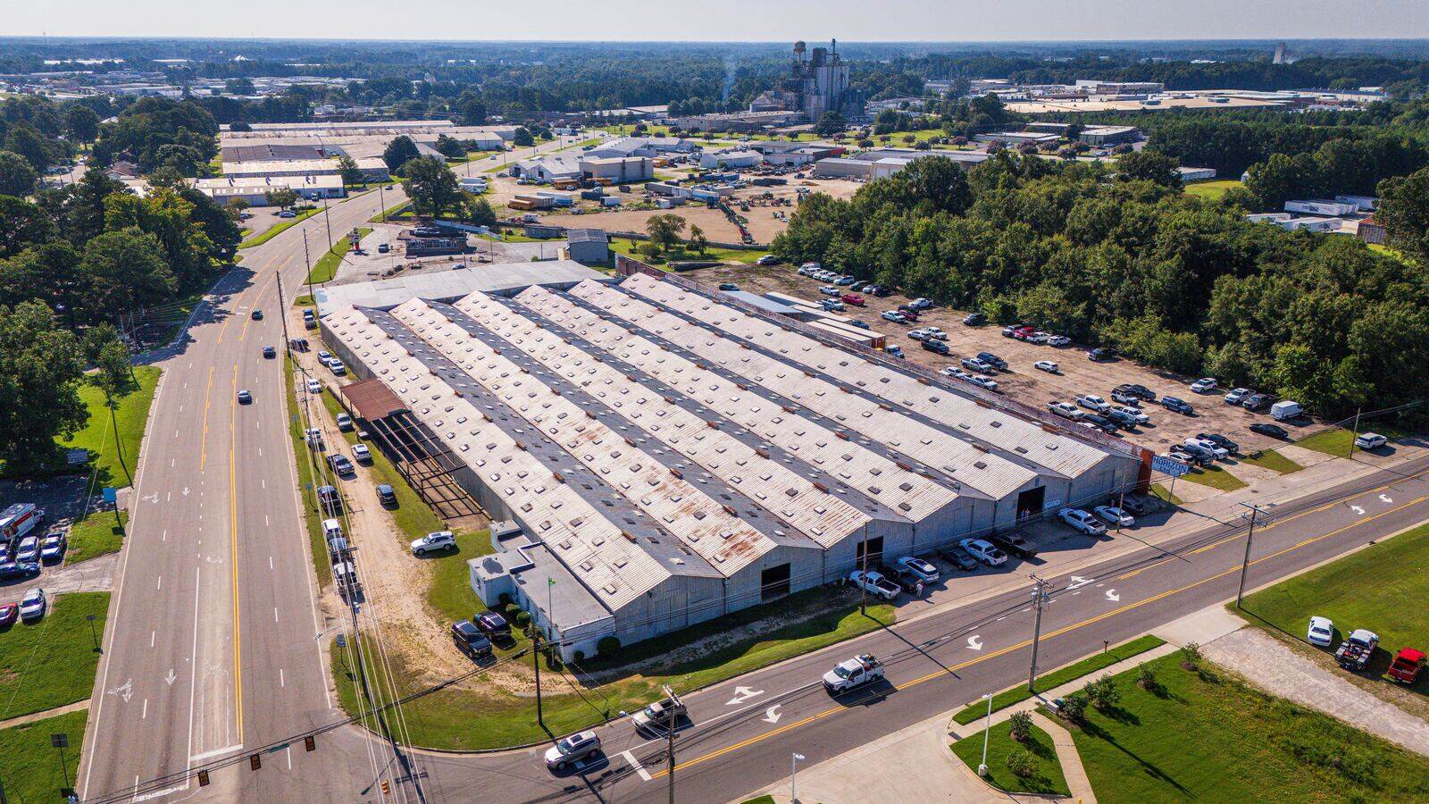 Aerial view of long warehouse buildings beside a divided road