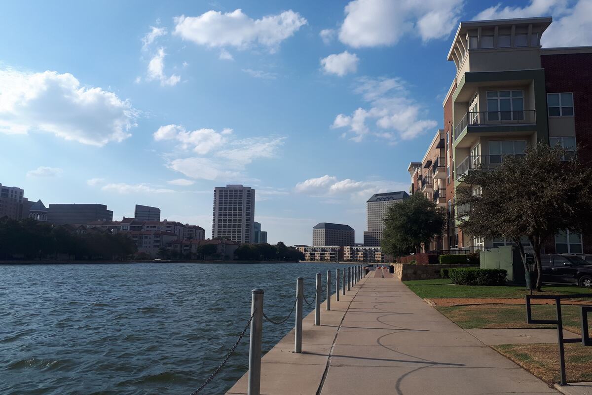 Waterside mid-rise apartment buildings along a paved lakefront path