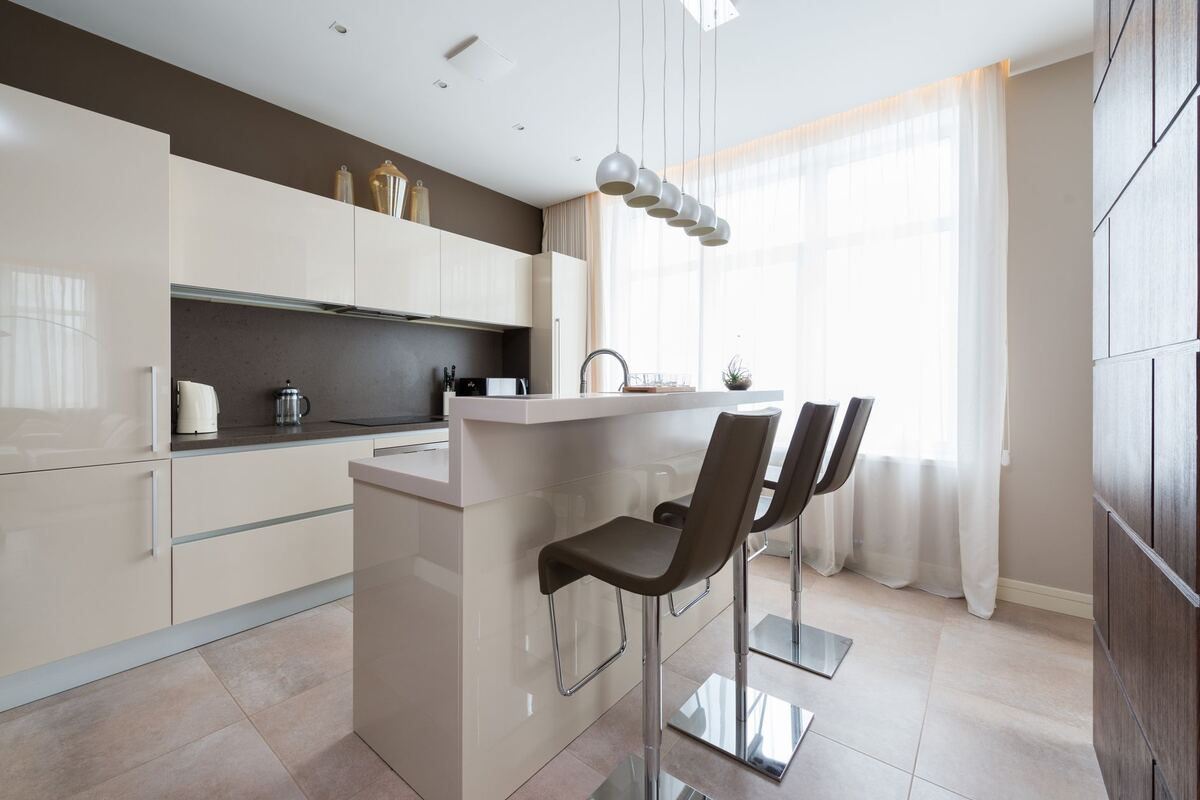 White apartment kitchen with a breakfast bar and stools